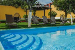 a swimming pool with chairs and a gazebo at Gran Misiones Tequisquiapan in Tequisquiapan