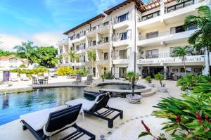 a hotel with two chairs and a swimming pool at Playa Laguna Vacation Condos in Sosúa