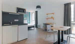 una piccola cucina e una sala da pranzo con tavolo di Student Factory Lille Euratechnologies a Lille