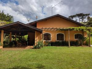 ein Haus mit einem Rasenplatz davor in der Unterkunft Sítio entre Santo Antonio Pinhal e Campos do Jordão in Santo Antônio do Pinhal