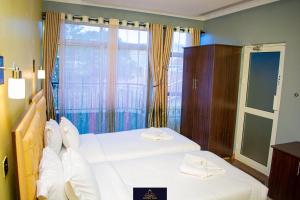 a bedroom with two beds and a large window at HOTEL TAJI in Nanyuki