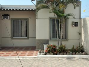 une maison avec un palmier en face dans l'établissement Casa Amueblada en Salinas, à Salinas