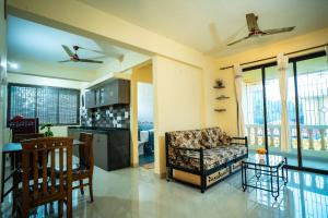 a living room with a couch and a kitchen at Field stone Apartment in Varca