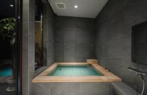 a bathroom with a bath tub with a shower at JADE Amber Resort Hakuba in Hakuba +249 photos