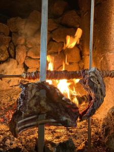 a piece of meat is cooking in a brick oven at Il Rifugio in Baunei