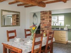 eine Küche und ein Esszimmer mit einem Tisch und Stühlen in der Unterkunft 1 Royal Oak Cottages in Shrewsbury