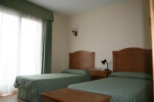 a hotel room with two beds and a window at Hotel Austria 76 in Puerto de Sagunto