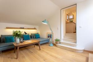 uma sala de estar com um sofá azul e uma mesa em Loft Terrasse, l'Hauture, Arles em Arles