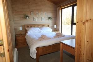 En eller flere senge i et værelse på Hartland Hideaway Lodge