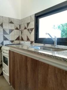 una cocina con fregadero y ventana en Casa EBEL, en Alpa Corral