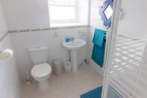 a white bathroom with a toilet and a sink at Utopia Apartments in Perranporth +8 photos