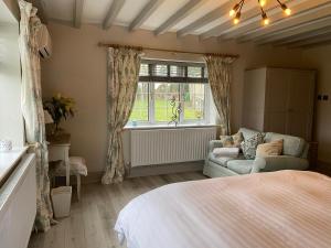 a bedroom with a bed and a couch and a window at Ticketyboo Suites in Pickering