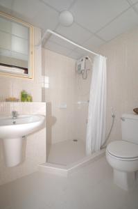 y baño con aseo, lavabo y ducha. en Rangsit Apartment I, en Ban Talat Rangsit