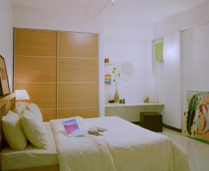 a bedroom with a bed with a book on it at Rangsit Apartment I in Ban Talat Rangsit