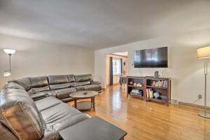 a living room with a leather couch and a flat screen tv at Pittsburgh Townhome about 5 Miles to Market Square in Pittsburgh