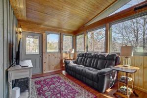 a living room with a couch and a tv at Cozy Log Cabin 6 Mi to Great Smoky Mtns NP! in Townsend