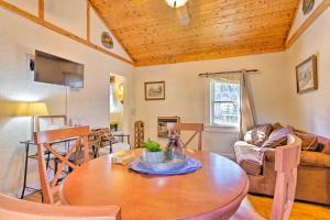 a living room with a wooden ceiling and a table at Screened Porch The Rock Cottage in Hot Springs in Hot Springs