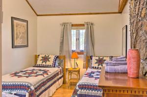 a bedroom with two beds and a table and a window at Screened Porch The Rock Cottage in Hot Springs in Hot Springs