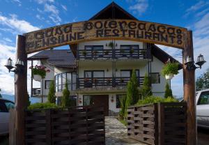 a building with a sign in front of it at Pensiunea Casa Boiereasca in Peştera