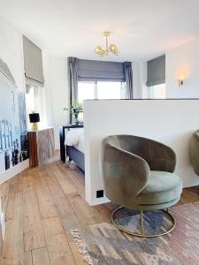 a living room with a chair and a bedroom at Boutique hotel Hippe Hendrik in Hendrik-Ido-Ambacht