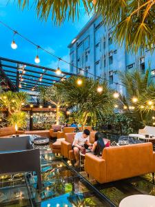 two people sitting on couches in a hotel lobby at Letana Hotel in Bang Phli