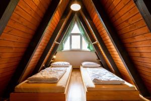 deux lits dans une chambre avec une fenêtre dans l'établissement Ferienwohnpark Immenstaad am Bodensee Nurdachhaus Typ 7 ND 33, à Immenstaad am Bodensee