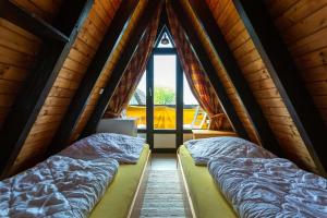 deux lits dans une chambre avec une fenêtre dans l'établissement Ferienwohnpark Immenstaad am Bodensee Nurdachhaus Typ 7 ND 48, à Immenstaad am Bodensee