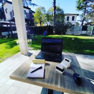 un ordenador portátil sentado en una mesa de madera con un libro en Anda e Rianda, en Campi Bisenzio