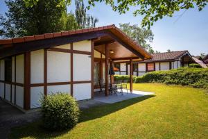 ein kleines Haus mit einem Tisch und Stühlen im Hof in der Unterkunft Ferienwohnpark Immenstaad am Bodensee Satteldachhaus Typ 10 SDS 048 in Immenstaad am Bodensee