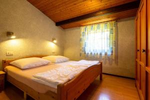 Schlafzimmer mit einem großen Bett und einem Fenster in der Unterkunft Ferienwohnpark Immenstaad am Bodensee Satteldachhaus Typ 10 SDS 048 in Immenstaad am Bodensee