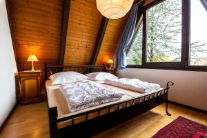 uma cama num quarto com uma grande janela em Ferienwohnpark Immenstaad am Bodensee Nurdachhaus Typ 8 NDW 114 em Immenstaad am Bodensee