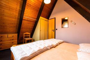 een slaapkamer met 2 bedden en een stoel in een kamer bij Ferienwohnpark Immenstaad am Bodensee Nurdachhaus Typ 8 NDT 089 in Immenstaad am Bodensee