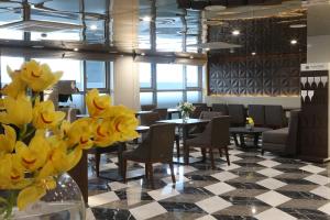 un restaurante con mesas, sillas y flores amarillas en Aventree Hotel Busan en Busan