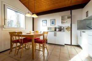 una cucina con un tavolo e sedie in una stanza di Ferienwohnpark Immenstaad am Bodensee Satteldachhaus Typ 9 SD 11 a Immenstaad am Bodensee