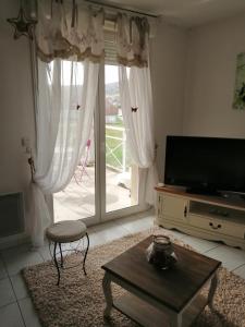 a living room with a large sliding glass door at Nid douillet au calme in Larche