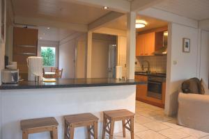 - une cuisine avec un comptoir et quelques tabourets dans l'établissement Ferienwohnpark Immenstaad am Bodensee Ferienhaus Normannenweg, à Immenstaad am Bodensee 7 autres photos