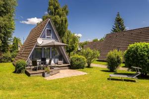 ein kleines Haus mit Dachschräge auf einem Rasen in der Unterkunft Ferienwohnpark Immenstaad am Bodensee Nurdachhaus Typ 7 ND 40 in Immenstaad am Bodensee