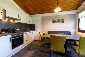 una cucina con tavolo da pranzo e sedie gialle di Ferienwohnpark Immenstaad am Bodensee Satteldachhaus Typ 9 SD 21 a Immenstaad am Bodensee