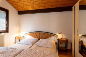 una camera da letto con un letto con soffitto in legno di Ferienwohnpark Immenstaad am Bodensee Satteldachhaus Typ 9 SD 21 a Immenstaad am Bodensee