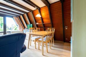 a dining room with a wooden table and chairs at Ferienwohnpark Immenstaad am Bodensee Nurdachhaus Typ 7 ND 45 in Immenstaad am Bodensee