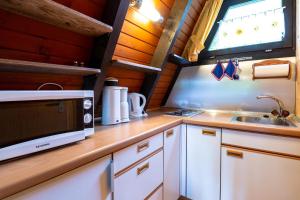 a kitchen with a sink and a microwave at Ferienwohnpark Immenstaad am Bodensee Nurdachhaus Typ 7 ND 45 in Immenstaad am Bodensee