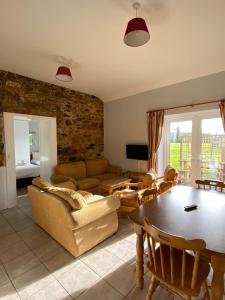a living room with a couch a table and chairs at Moneylands Farm Self-Catering Apartments in Arklow