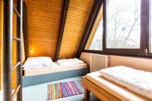 2 camas en una habitación con 2 ventanas en Ferienwohnpark Immenstaad am Bodensee Nurdachhaus Typ 8 NDW 080, en Immenstaad am Bodensee