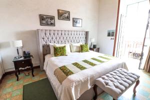 a bedroom with a large bed with a large window at Quinta Alhóndiga Galindo Hotel Boutique in Cholula