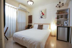 sypialnia z białym łóżkiem i oknem w obiekcie RaRa Stay w mieście Taizhong