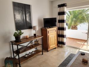 a living room with a tv on a wooden cabinet at Casa Para Ti Delfinesse in Puerto del Carmen