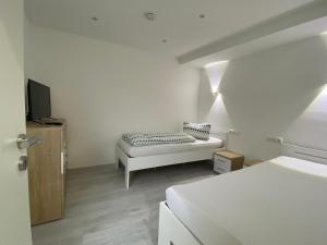 een witte kamer met een bed en een bank bij Ferienwohnung H&M Immobilien Hettstedt in Hettstedt