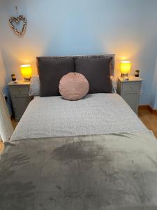 een bed met twee lampen en een roze kussen erop bij The little crab hut in Sheringham