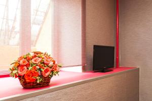 a basket of flowers sitting on a window sill with a television at Castello Hotel in Moscow