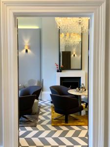 a room with a table, chairs and a mirror at Eccleston Square Hotel in London